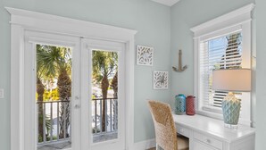 A room with a white desk, a chair, a window with blinds, and decorative items on the windowsill. - Ocean Walk- 5 bedroom heated pool/spa and 6 houses from the white sandy beach (Anna Maria)