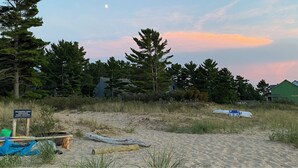 A beach with a sign indicating a wilderness condo association permit is required. - The Little Green Cottage in the Woods (Glen Arbor)