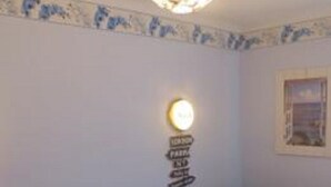 Ein Schlafzimmer mit einem Bett, einem Nachttisch, einer Wandleuchte und einem Schild mit Pfeilen.