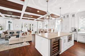 Una cocina amplia con armarios blancos, una isla grande y techo de madera.