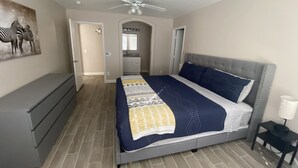 A bedroom with a bed, a dresser, a ceiling fan, and a zebra painting on the wall. - One story, 3bedrooms. 15 min from Strip. Quiet & and safe. (Las Vegas)