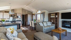 A spacious living area with a sofa set, a coffee table, and a TV. - 2 bedroom accommodation in Addlethorpe, near Skegness (Addlethorpe, near Skegness)