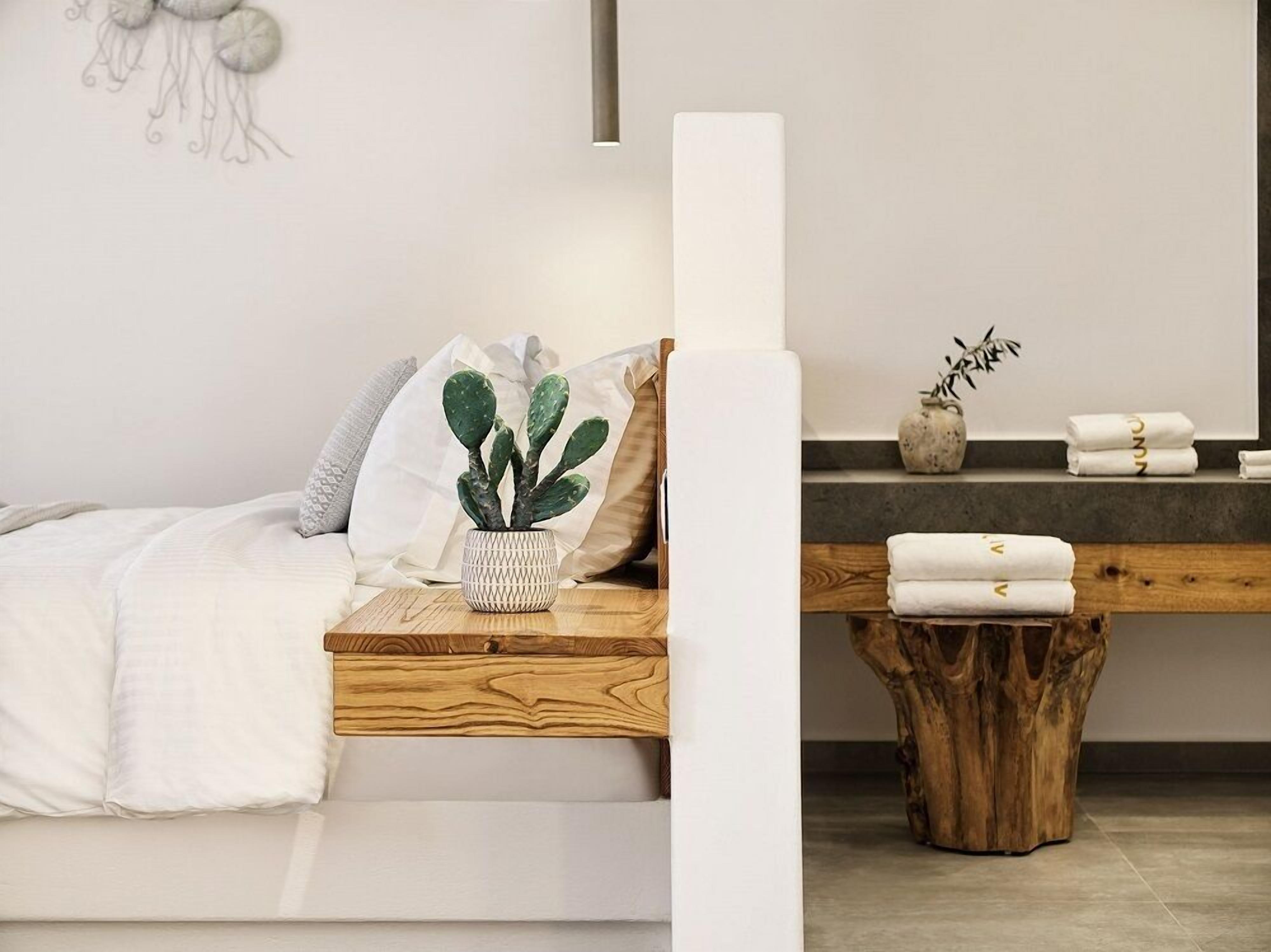 Une chambre moderne avec une table de chevet en bois, une plante succulente et un tabouret en bois.
