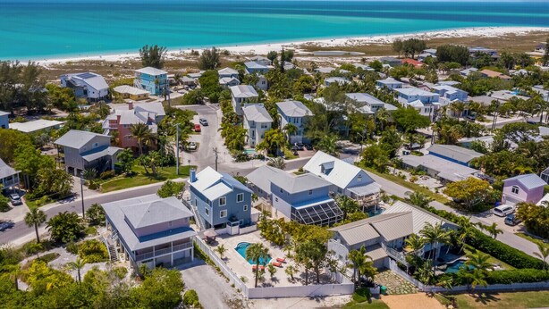 Un quartier résidentiel situé sur la côte, avec des maisons, une plage et une piscine.
