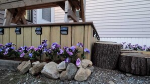 A wooden planter box with flowers and rocks.