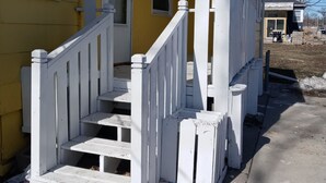 Ein gelbes Haus mit weißem Veranda und der Hausnummer 240.