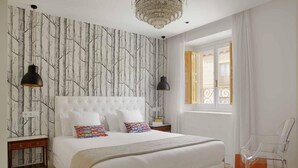 Quarto com uma cama grande, duas luminárias de cabeceira, um candelabro e uma janela com cortinas.