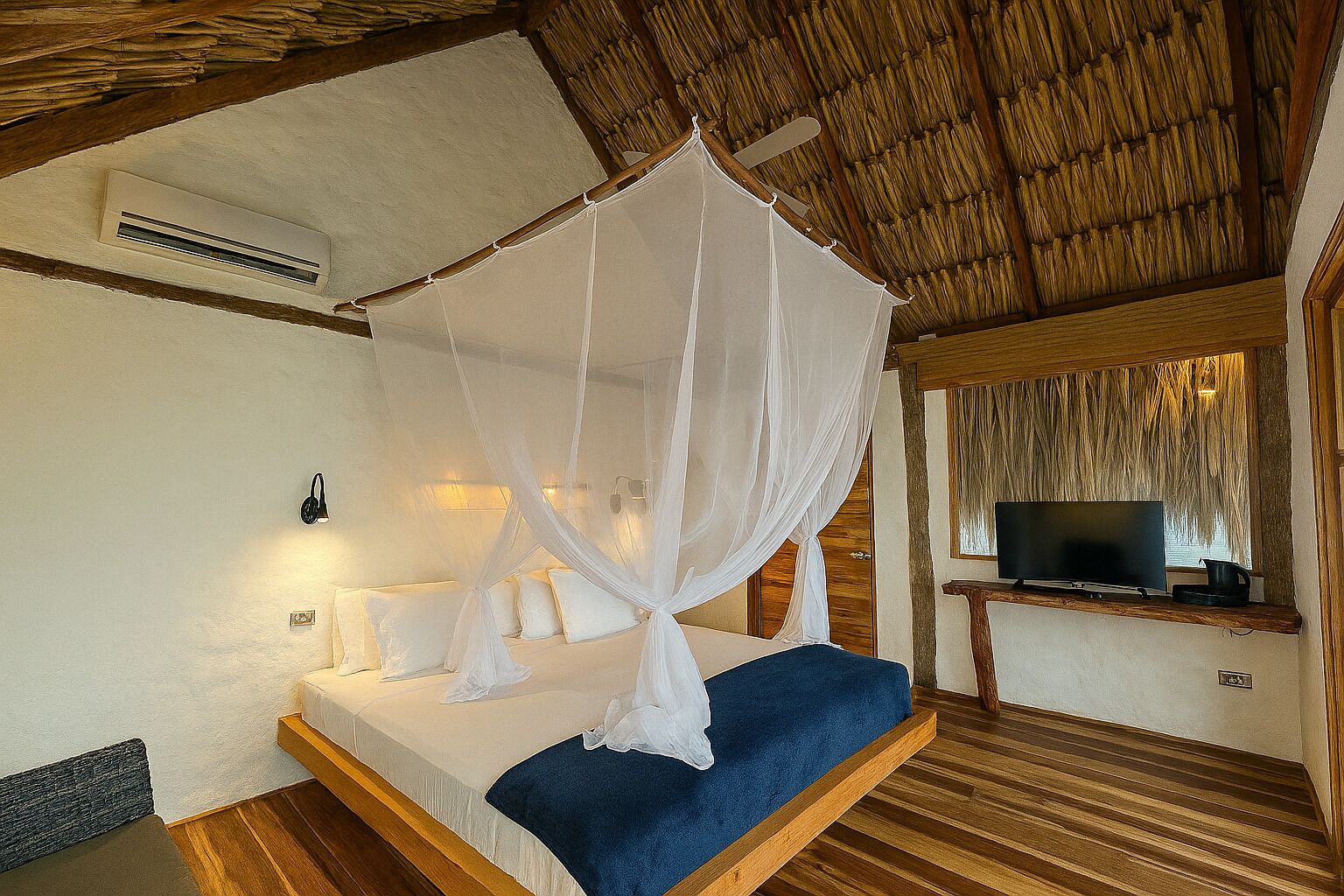 A bedroom with a bed, a TV, and a mosquito net.