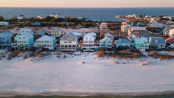 Un quartier résidentiel situé sur la côte, avec des maisons donnant directement sur la plage.