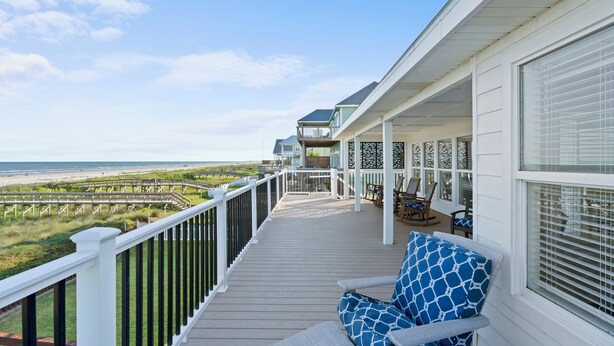 A covered deck with a view of the beach, outdoor furniture, and a railing. - A Time to Lime by Ryson Vacation Rentals (Galveston)