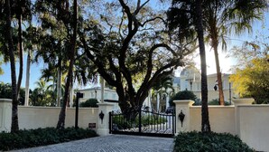 A gated entrance with a cobblestone driveway leading to a large tree-lined area. - Sarasota-Indian Beach Zen Home (private-pet friendly)  (Sarasota)