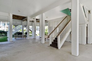 Un espacio al aire libre cubierto con una escalera de madera, bancos y vistas de edificios al fondo.