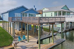 Une propriété située au bord de l’eau, dotée d’une terrasse, d’un espace salon extérieur et d’un quai s’avançant dans l’eau.
