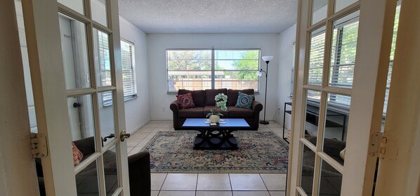 A room with a brown sofa, a blue coffee table, and a patterned rug.