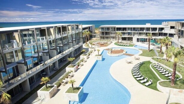 A modern hotel with a swimming pool, multiple balconies, and a view of the ocean. - Torquay285 King Studio Beachfront Resort (Torquay)
