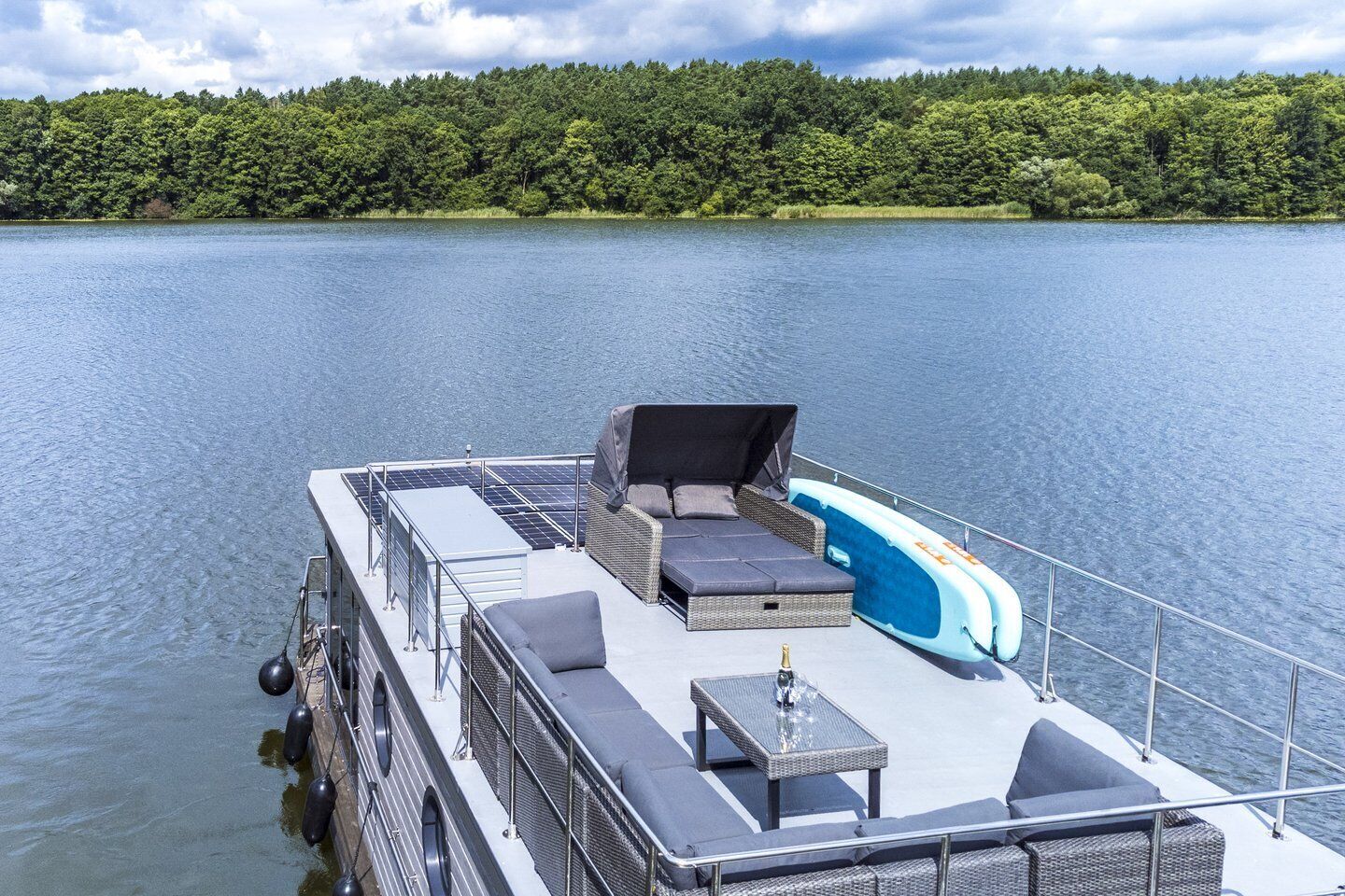 A boat deck with a seating area, a table, and a covered space.