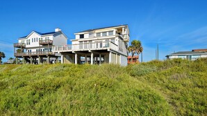 A two-story beachfront house with a balcony and a covered porch. - Brannen's Beachfront by Ryson Vacation Rentals (Galveston)