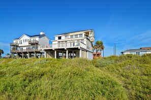 A two-story beachfront house with a balcony and a covered porch. - Brannen's Beachfront by Ryson Vacation Rentals (Galveston)