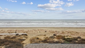A beach with a clear sky and waves. - Brannen's Beachfront by Ryson Vacation Rentals (Galveston)