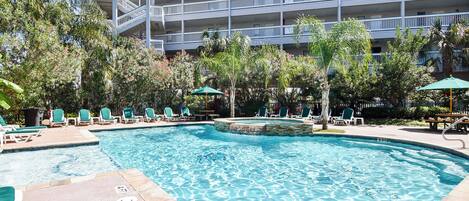 A swimming pool with lounge chairs and a building in the background.
