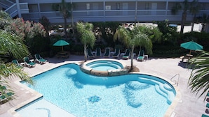 A swimming pool with multiple levels of seating and palm trees. - Turtle Haven by Ryson Vacation Rentals (Galveston)