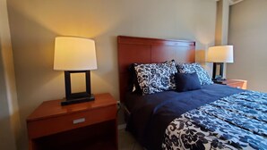 A hotel room with a bed, two bedside tables with lamps, and a nightstand with a drawer. - Lovely 2 Bdrm apartment with private terrace with grill (Tijuana)