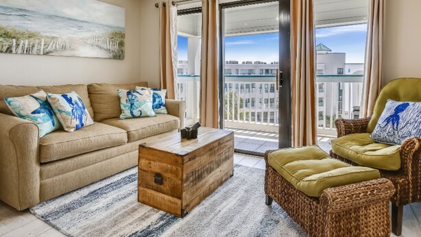 Un salon avec un canapé beige, une table basse en bois et un fauteuil en osier.