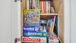 A bookshelf with various board games and books.