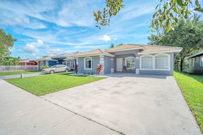 A residential area with houses featuring a consistent architectural style, a driveway, and a well-maintained lawn.