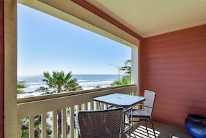 A balcony with a view of the ocean, a table, two chairs, and a potted plant. - Dawn 631 by Ryson Vacation Rentals (Galveston)
