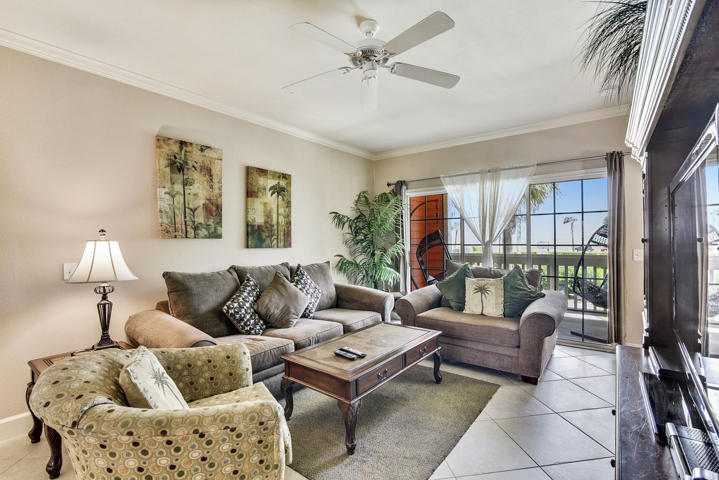 A living room with two sofas, a coffee table, a lamp, and a ceiling fan.