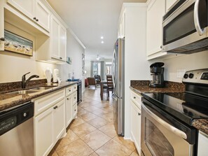 Enjoy cooking in this well-equipped kitchen with a refrigerator, microwave, stove, and dishwasher.
