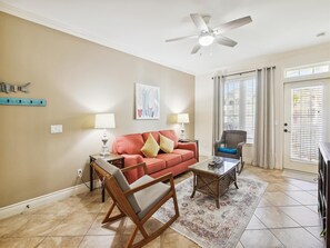 Relax in this inviting living room with a sofa, coffee table, and wicker chair.