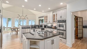 A modern kitchen with white cabinetry, stainless steel appliances, and a large island. - Big Canoe Mountain Home with Spectacular Mountain Views - Game room! (Jasper)