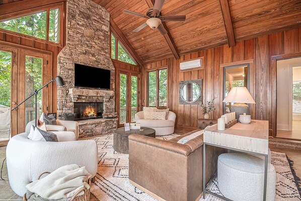 Relax by the stone fireplace, surrounded by comfortable seating and natural elements.
