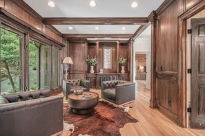 Relax in this stylish living area with a large sofa, armchairs, and a cowhide rug.