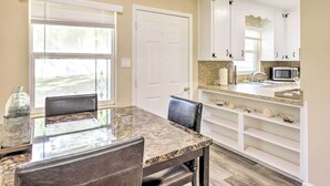 A kitchen with white cabinets, a granite countertop, and a microwave. - < 1 Mi to Lake Weir: Quiet Summerfield Getaway (Summerfield)