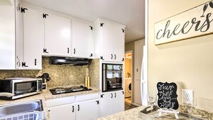 A kitchen with white cabinets, a microwave, a toaster, and a chalkboard sign. - < 1 Mi to Lake Weir: Quiet Summerfield Getaway (Summerfield)