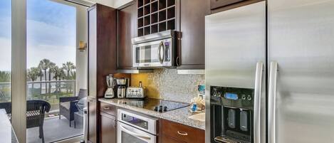 Una cocina moderna con un refrigerador de acero inoxidable, un microondas y un horno empotrado.