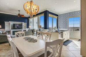 A modern kitchen with a dining area, large windows, and a view of the landscape. - Blue Haven by Ryson Vacation Rentals (Galveston)
