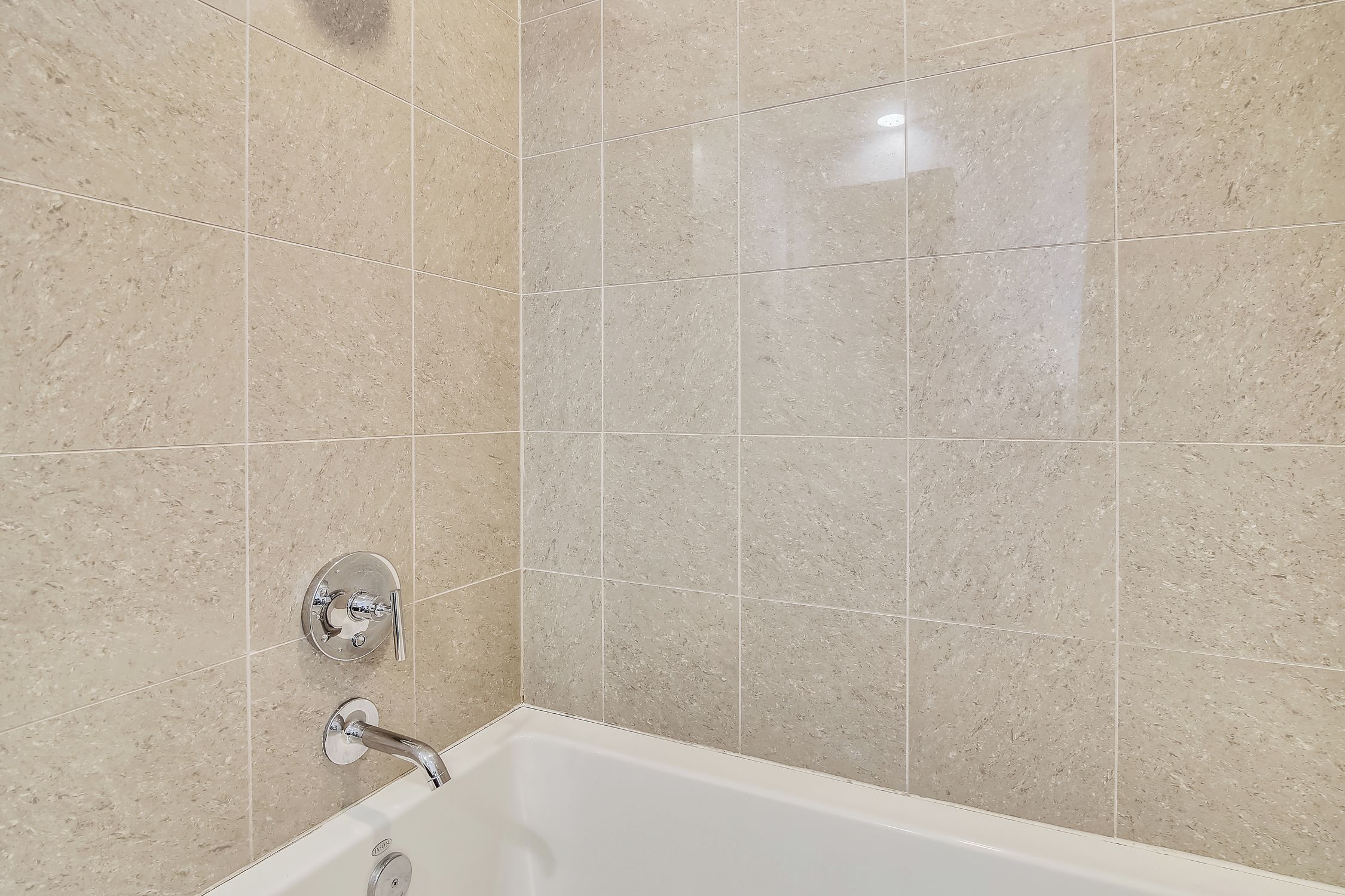 Un baño con una bañera, ducha y grifo empotrado.