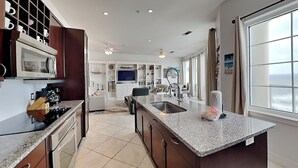 Una cocina moderna con una isla central, horno empotrado y un amplio ventanal con vistas.