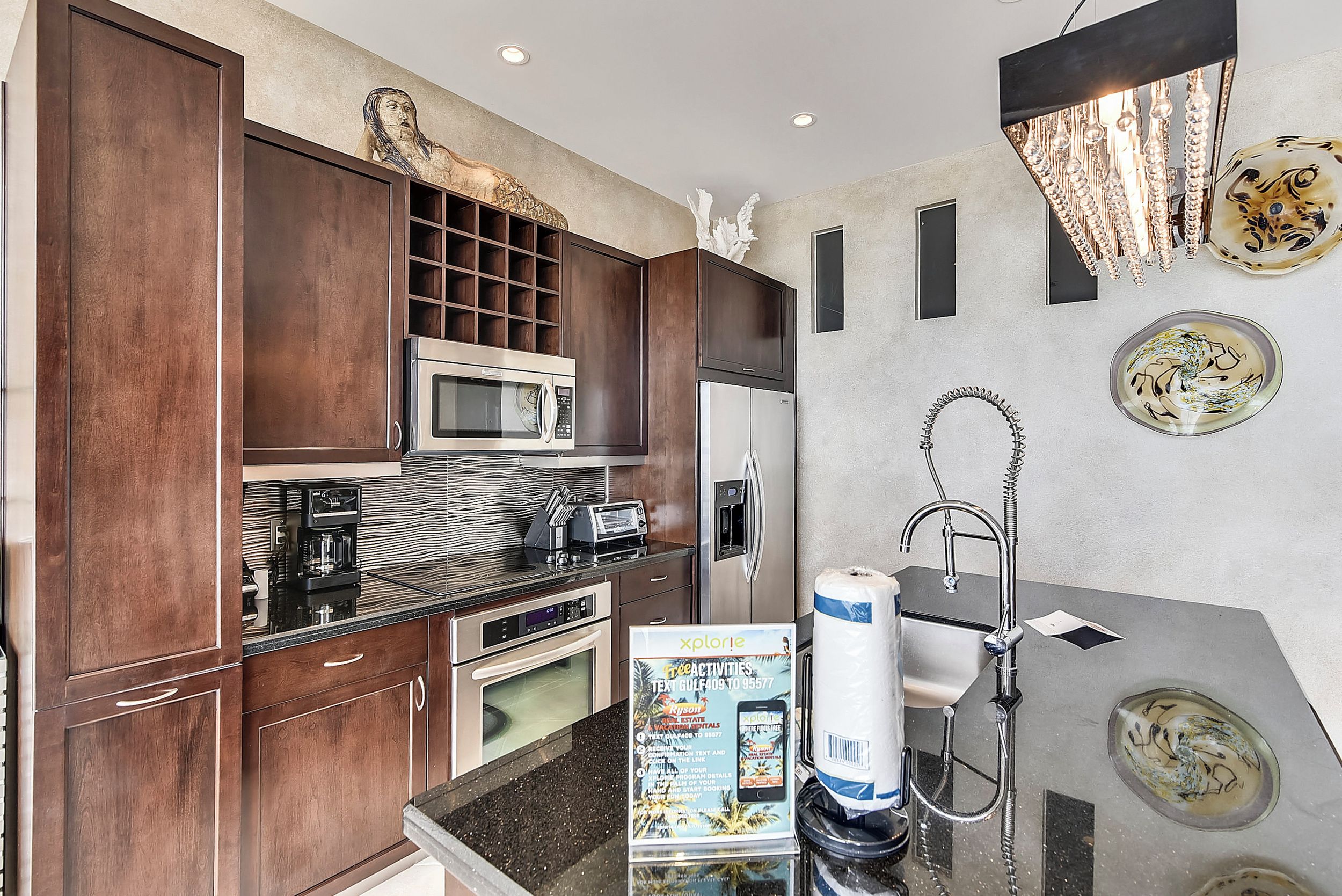 A modern kitchen with dark wood cabinets, a stainless steel refrigerator, a microwave, and a coffee maker.