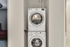 Uma máquina de lavar e secar empilhadas em uma lavanderia.