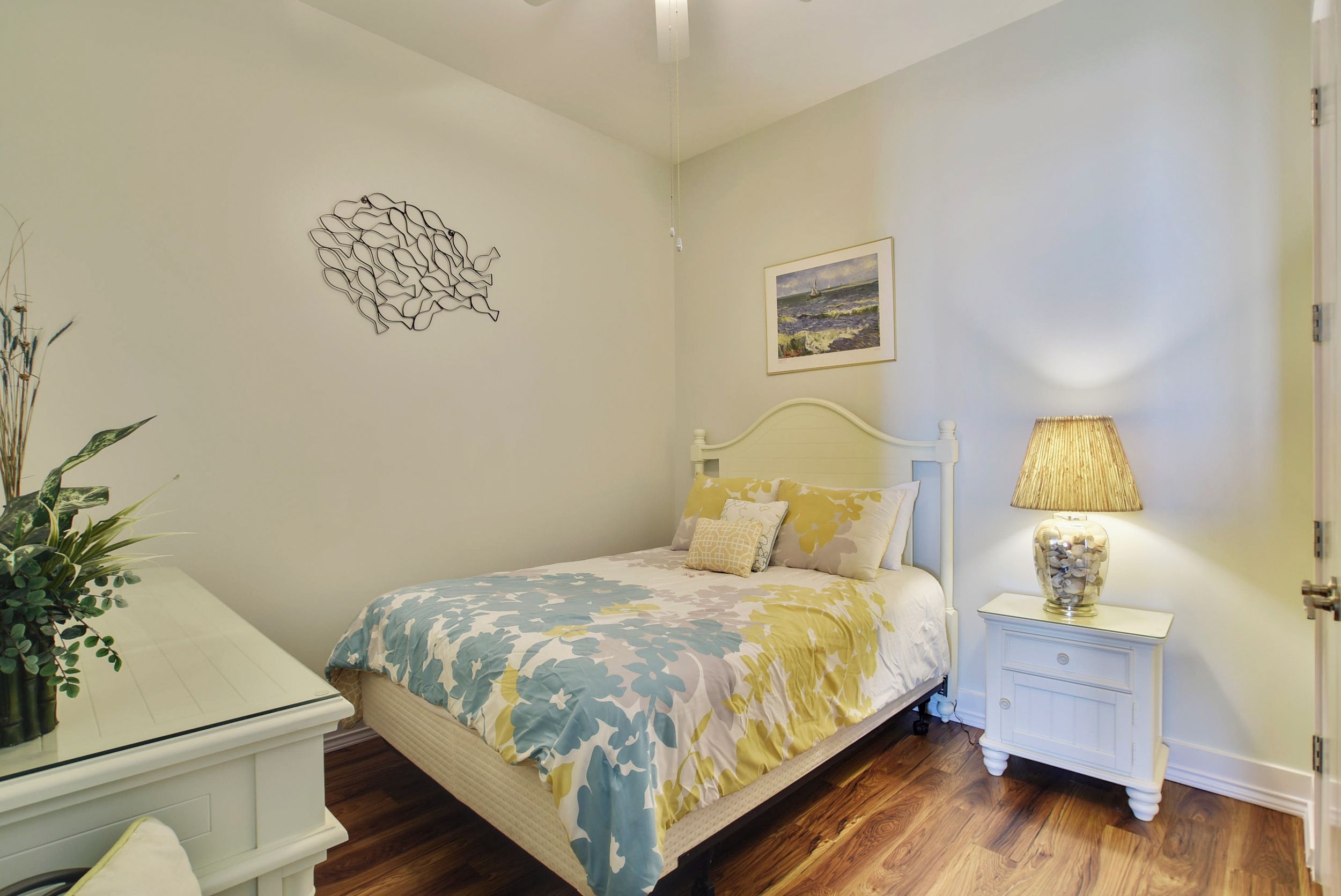 Un dormitorio con cama, mesita de noche, lámpara y decoración en la pared.