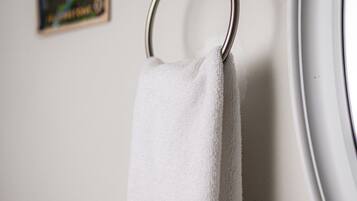 A white towel hanging on a metal ring.