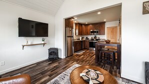 A modern kitchen with wooden cabinets, stainless steel appliances, and a dining area with a wooden table and chairs.