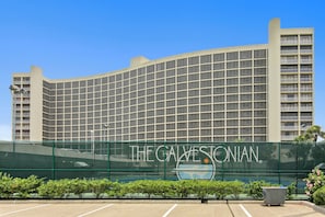 A large hotel with a curved facade and a prominent sign reading "The Galvestonian."