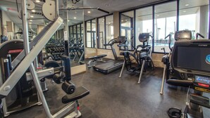 Ett gym med löpband, crosstrainers och utrustning för styrketräning.