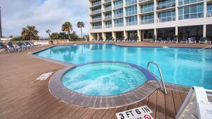 Ett poolområde vid hotellet med ett bubbelbad, solstolar och en skylt som anger ett vattendjup på 3 fot och 6 tum.